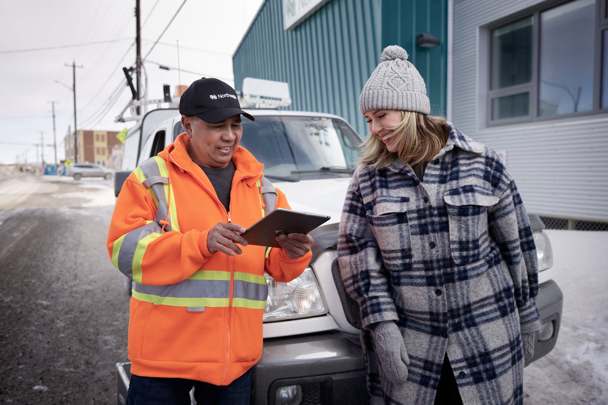 A photo of a Northwestel technician speaking with a community member in Northern Canada.