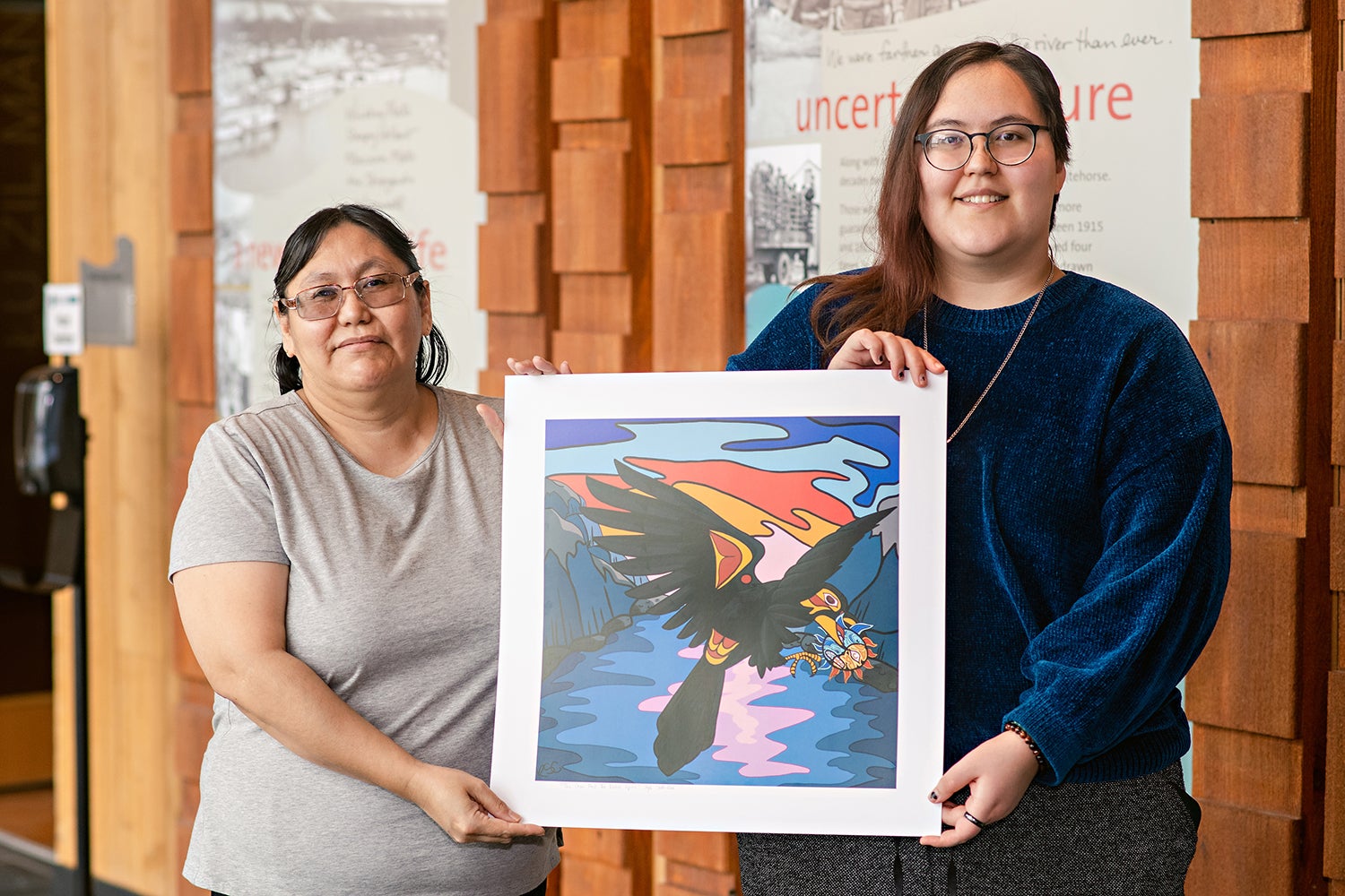 Kayla stands with her mom, Nita Clarke. Together, they're holding a copy of the Crow and The Native Spirit