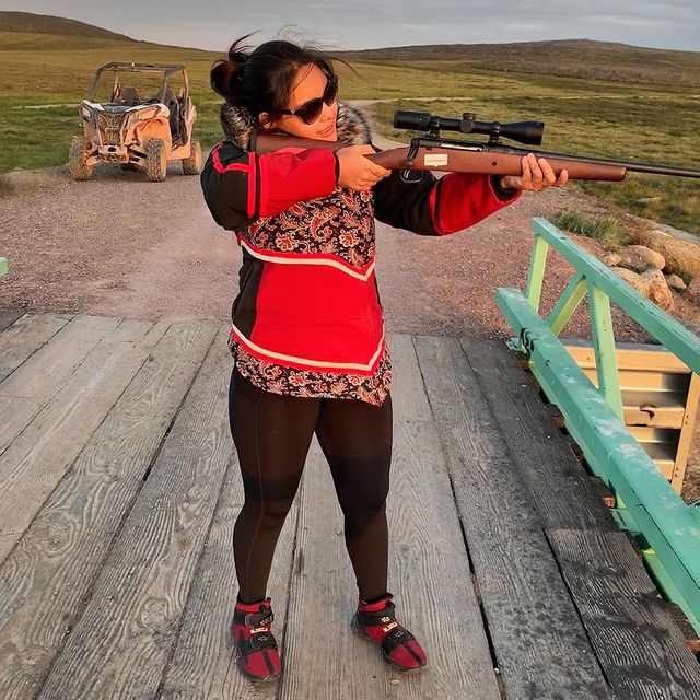 Kaytlyn with rifle on land alone