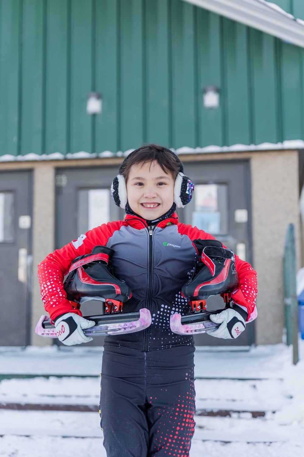 Brea smiles at the camera while holding her skates