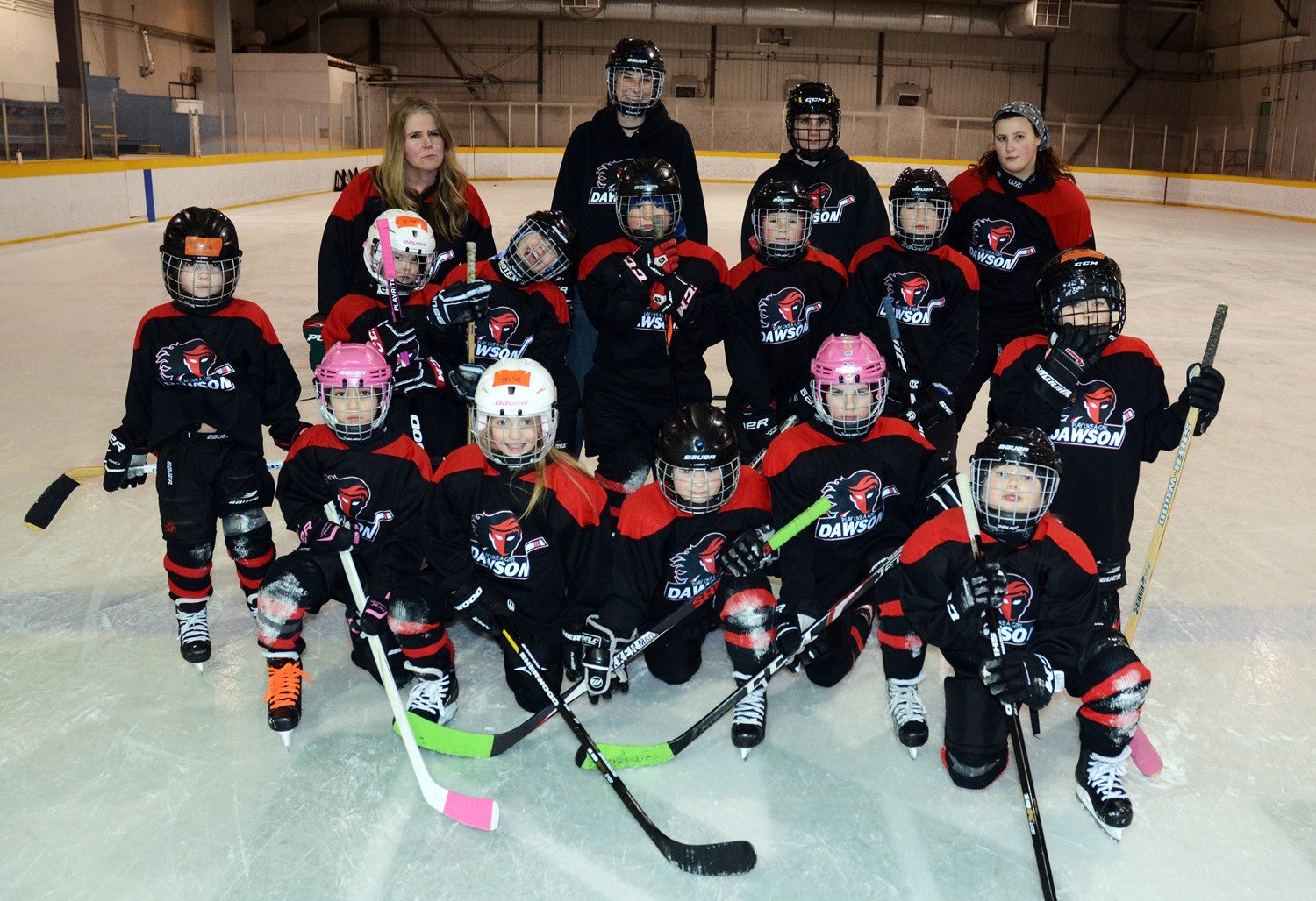 The Play like a Girl team pose for a photo on the ice.