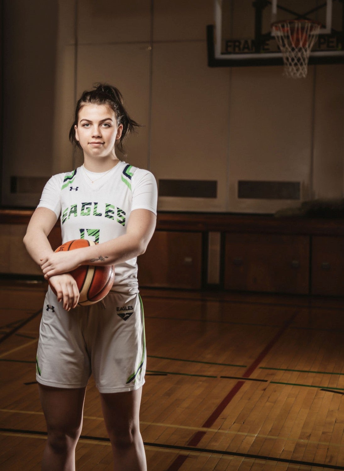 Grace holds a basketball while on the basketball court