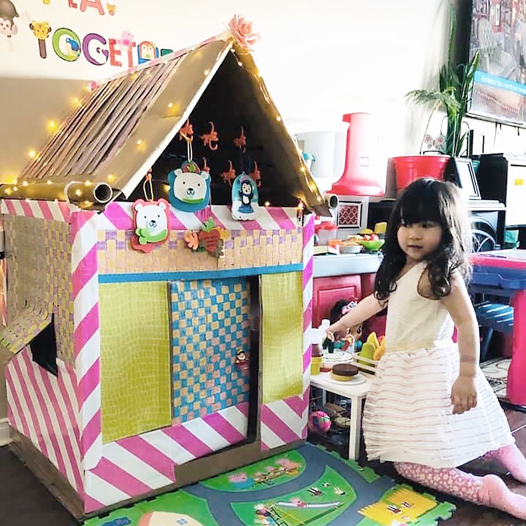 Child playing in a DIY Amazon box playhouse 