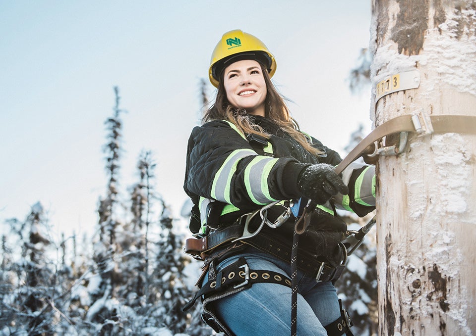 Photo of Service Tech, Nicole climbing a pole 