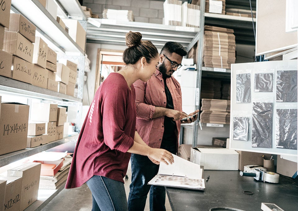 Two employees working on product development while looking at documents