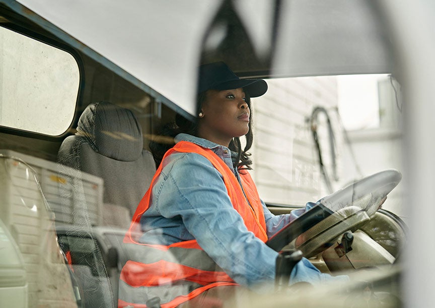 black female telecomunications worker driving warehouse heavy equipment