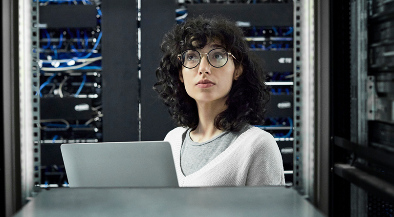 Woman working in a room surrounded by computing servers