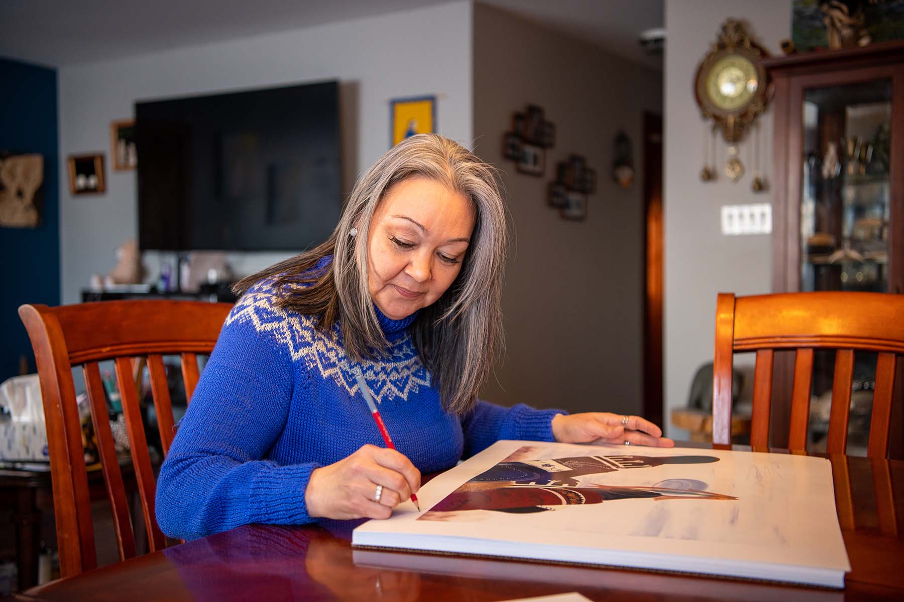 Dyan signing lithographs of “My ice hole” at her home in Rankin Inlet 