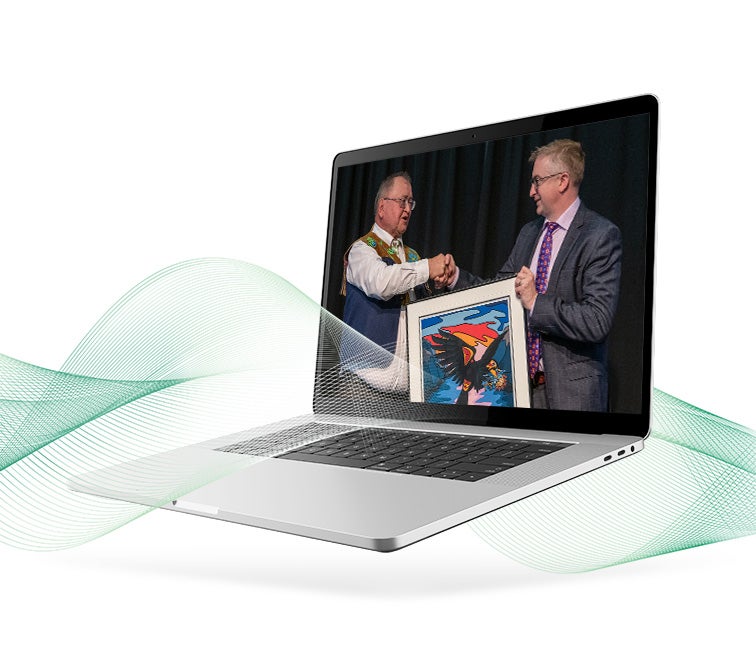 decorative image of Curtis Shaw and First Nations spokes person displayed in a laptop screen shacking hands