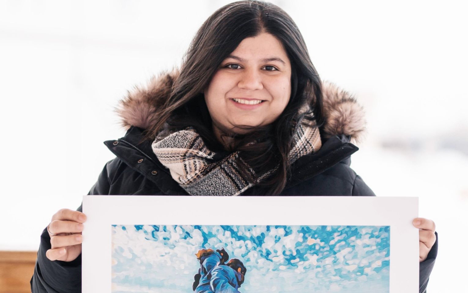 Sehrish Khan holding her artwork titled "The Ocean’s Touch"