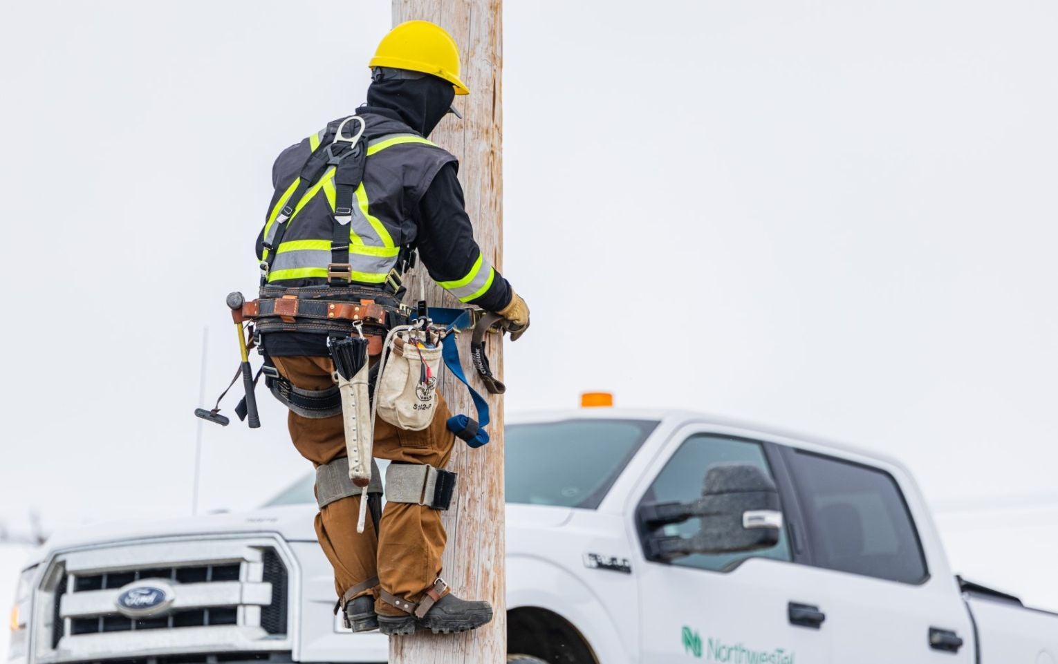 Northwestel technican climbing roadside pole