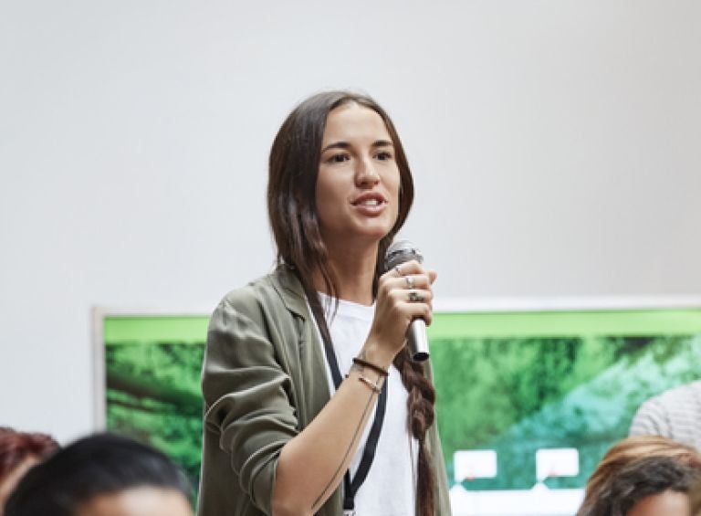 Woman speaking to a microphone to get her opinion count