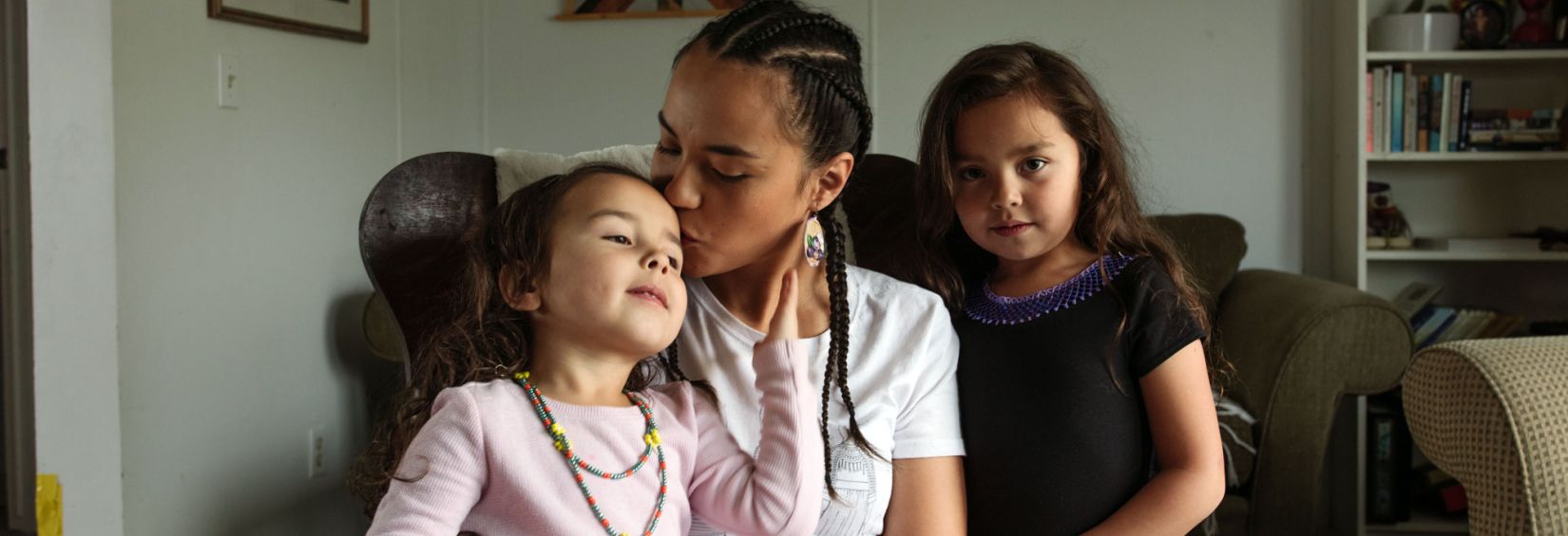 A photo of an Indigenous family from Northern Canada, sitting on a couch