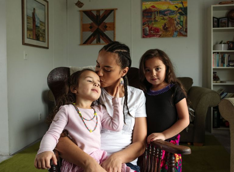 A photo of an Indigenous family from Northern Canada, sitting on a couch