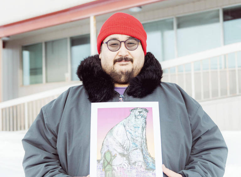 Joshua Qaumariaq holding his artwork - Nanurluk Shapeshifter