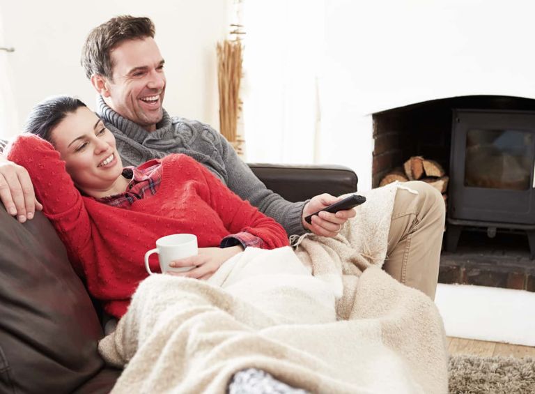 couple relaxing on couch watching tv