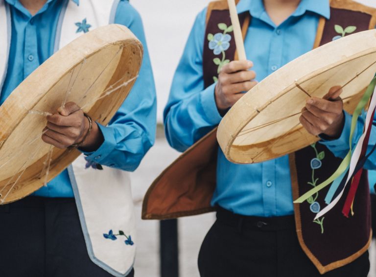 Indigenous drummers wearing traditional clothes playing for Indigenous day celebrations